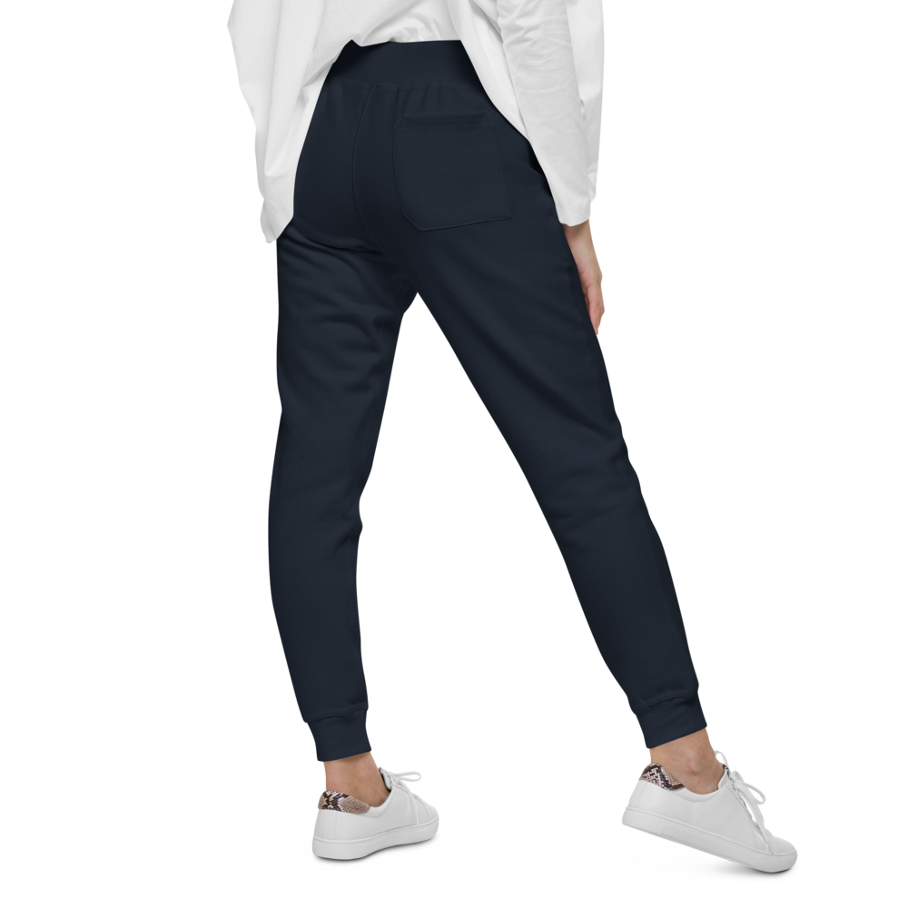 Person wearing navy jogger pants and white sneakers on a white background