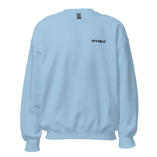 Light blue sweatshirt with 'IT'S OKAY' embroidered text on a white background